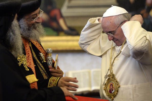 Pope Francis (R) puts on a neckless, gift from the Coptic Orthodox leader Tawadros II (L) during a private audience in the pontiff's library on May 10, 2013 at the Vatican. Tawadros II arrived in Rome the day before for a historic four-day visit to meet Pope Francis -- a sign of growing rapprochement between the Vatican and the Orthodox world.  AFP PHOTO / POOL / ANDREAS SOLARO        (Photo credit should read ANDREAS SOLARO/AFP/Getty Images)